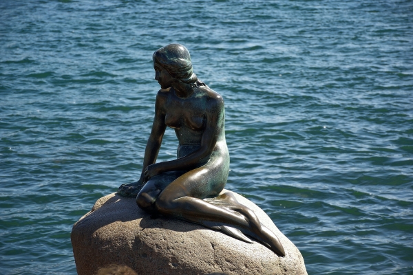 a statue of a mermaid sitting on a rock